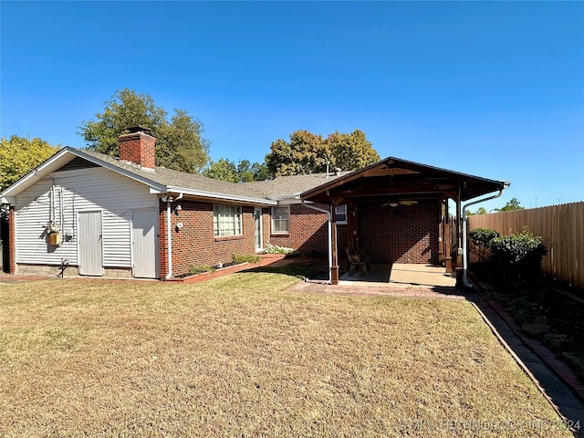 rear view of property with a yard and a patio area