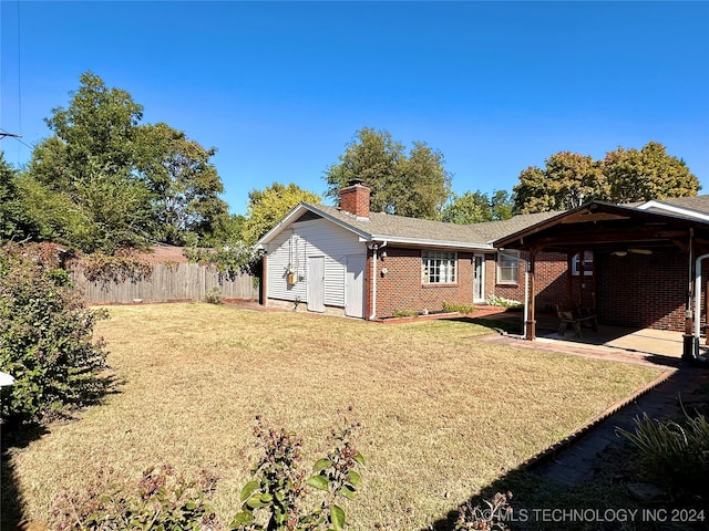 rear view of house with a yard and a patio area