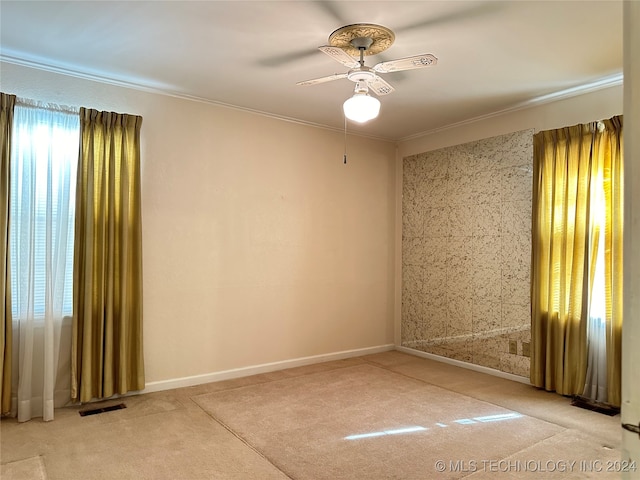 carpeted spare room featuring ornamental molding and ceiling fan