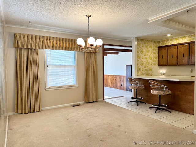 interior space with a textured ceiling, light carpet, pendant lighting, wooden walls, and ornamental molding