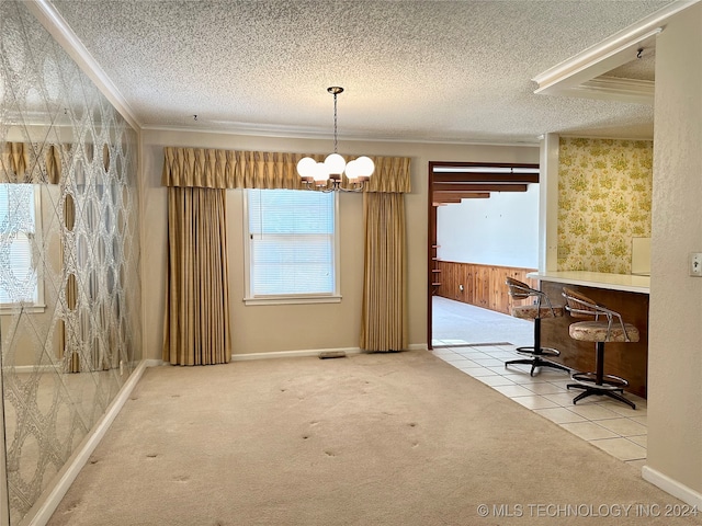 unfurnished dining area featuring crown molding, carpet, a textured ceiling, and a chandelier