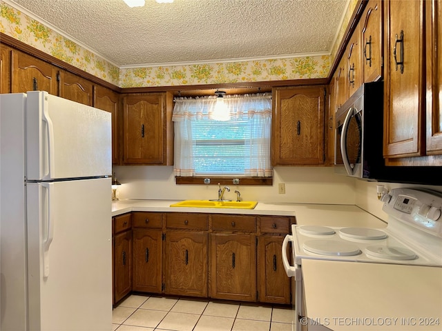 kitchen with ornamental molding, sink, light tile patterned floors, a textured ceiling, and white appliances