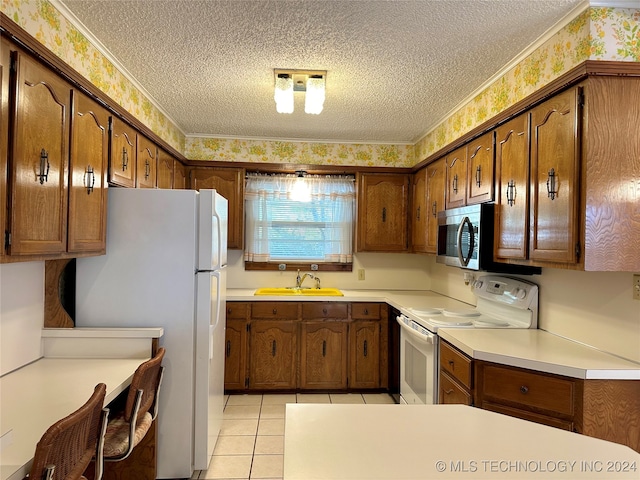 kitchen with white appliances, a textured ceiling, and sink