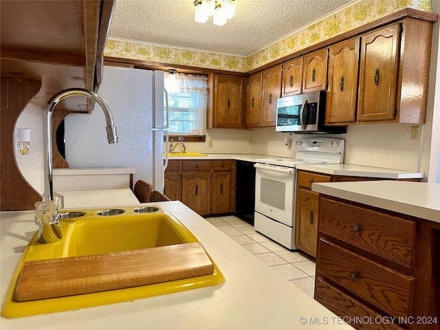 kitchen with white appliances, sink, a textured ceiling, beam ceiling, and light tile patterned floors