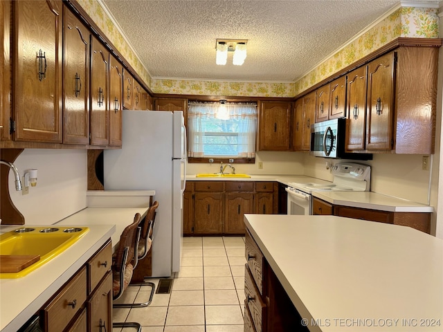 kitchen with crown molding, sink, light tile patterned flooring, a textured ceiling, and white appliances