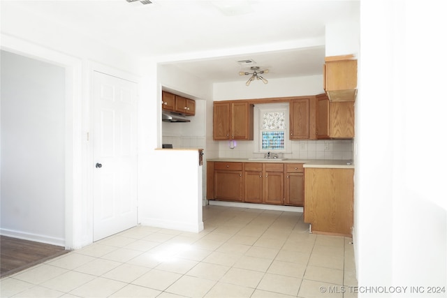 kitchen featuring tasteful backsplash, sink, and light tile patterned floors