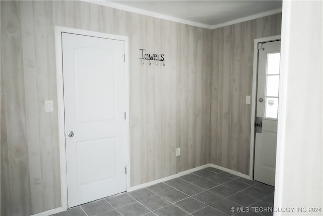 interior space featuring dark tile patterned floors and wooden walls