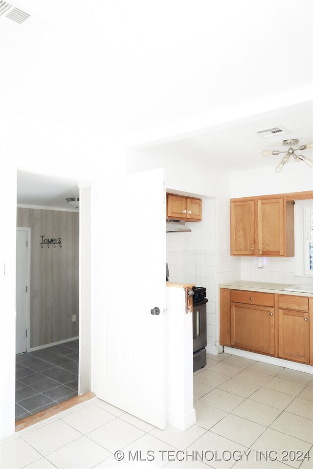 kitchen featuring black stove, ceiling fan, and light tile patterned floors