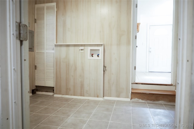 laundry area with hookup for a washing machine, wood walls, and light tile patterned flooring