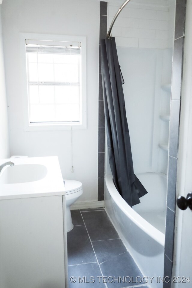 full bathroom featuring shower / bath combo with shower curtain, toilet, vanity, and tile patterned floors