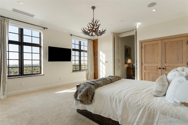 bedroom featuring a closet, crown molding, light colored carpet, and an inviting chandelier