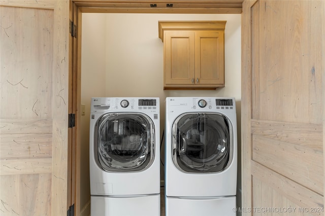 laundry room featuring washing machine and dryer and cabinets