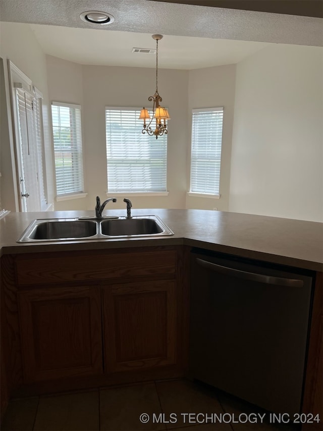 kitchen featuring hanging light fixtures, dark tile patterned floors, dishwasher, a notable chandelier, and sink