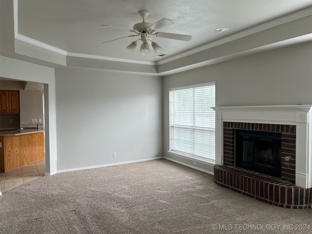 unfurnished living room with crown molding, carpet floors, and a brick fireplace