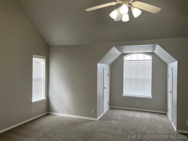 additional living space with light carpet, ceiling fan, and vaulted ceiling