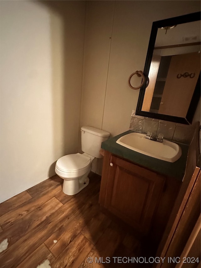 bathroom featuring vanity, hardwood / wood-style flooring, and toilet