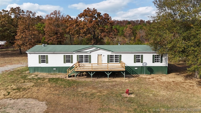 view of front facade with a wooden deck and a front yard