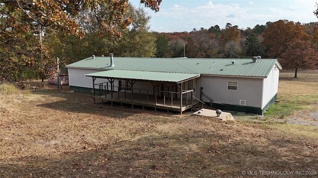 back of house with a deck