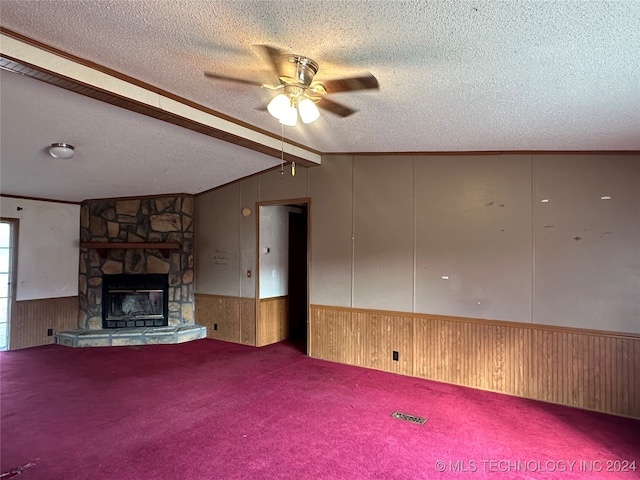 unfurnished living room with vaulted ceiling with beams, wooden walls, carpet, a textured ceiling, and ceiling fan