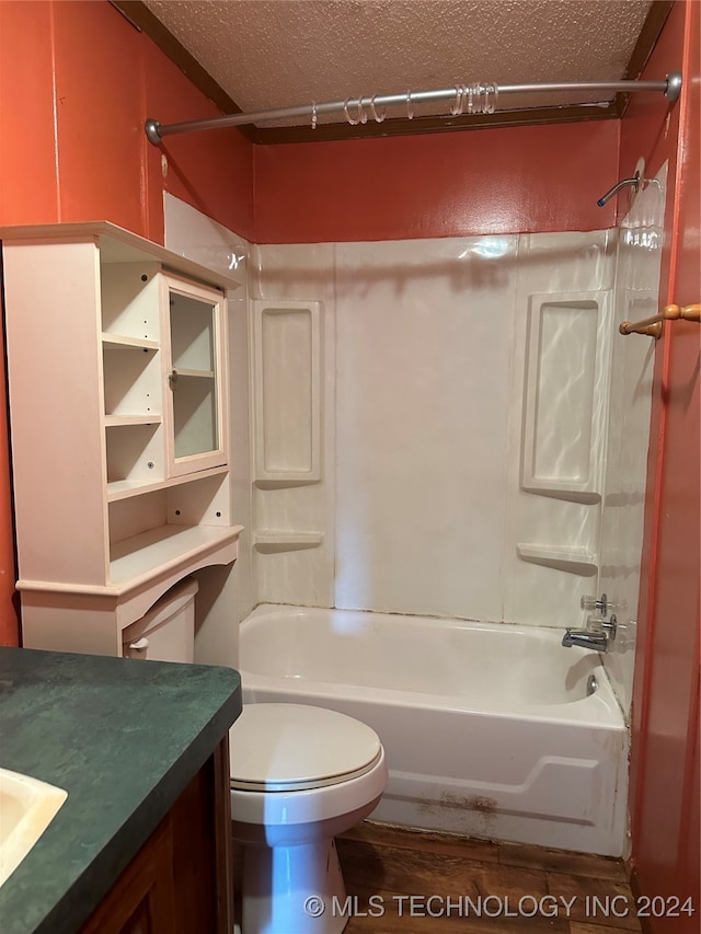 full bathroom featuring toilet, a textured ceiling, vanity, and washtub / shower combination