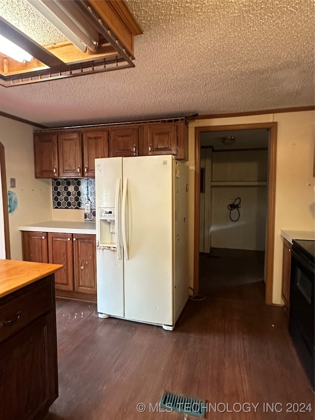 kitchen featuring a textured ceiling, white refrigerator with ice dispenser, tasteful backsplash, and dark hardwood / wood-style flooring