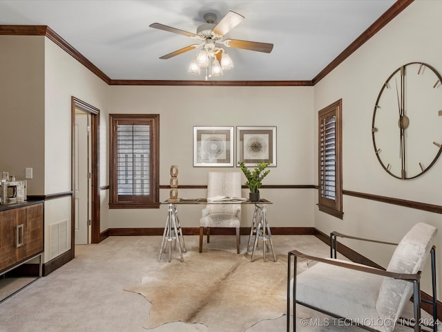 carpeted home office featuring crown molding and ceiling fan