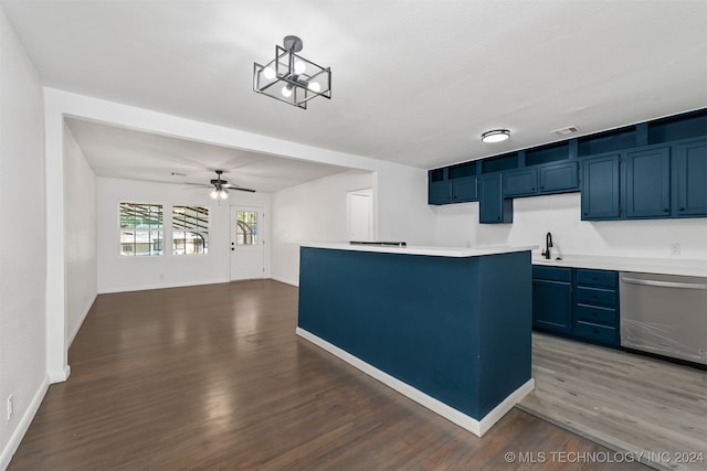 kitchen with blue cabinetry, stainless steel dishwasher, and dark wood-type flooring