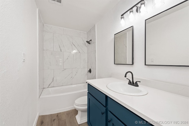 full bathroom featuring vanity, toilet, hardwood / wood-style flooring, and tiled shower / bath combo