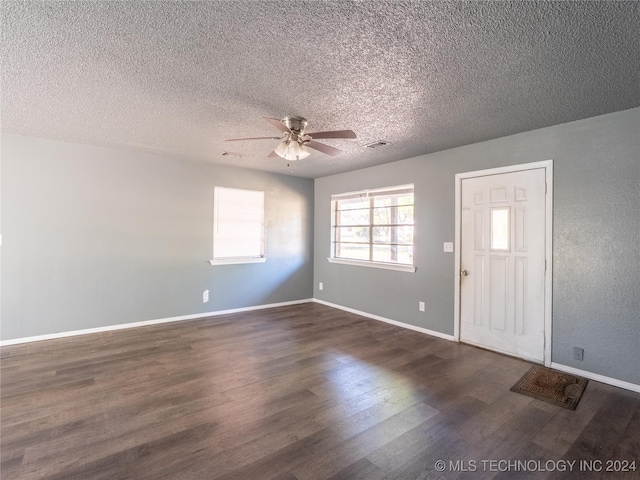 foyer with a textured ceiling, ceiling fan, and dark wood-type flooring