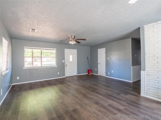 unfurnished living room featuring ceiling fan, dark hardwood / wood-style flooring, and a textured ceiling