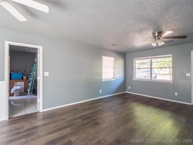 spare room featuring ceiling fan, dark hardwood / wood-style flooring, and a textured ceiling