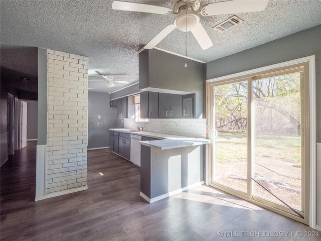 kitchen with kitchen peninsula, backsplash, white dishwasher, ceiling fan, and dark hardwood / wood-style floors