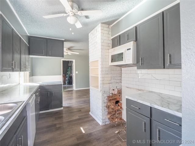 kitchen featuring dark hardwood / wood-style flooring, white appliances, a textured ceiling, ceiling fan, and sink