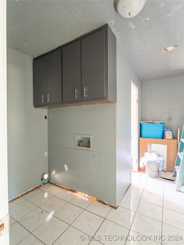 laundry area featuring cabinets, washer hookup, and a textured ceiling