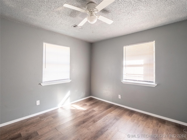 empty room with hardwood / wood-style floors, a textured ceiling, and ceiling fan