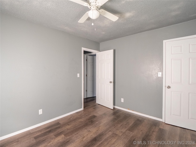 unfurnished bedroom featuring ceiling fan, dark hardwood / wood-style floors, and a textured ceiling