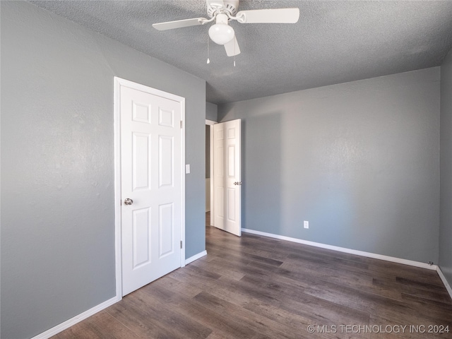 unfurnished room featuring a textured ceiling, ceiling fan, and dark wood-type flooring