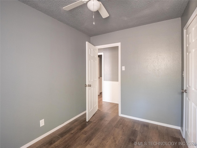 unfurnished bedroom featuring ceiling fan, dark hardwood / wood-style flooring, and a textured ceiling