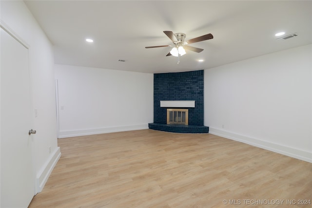 unfurnished living room featuring light hardwood / wood-style flooring, a brick fireplace, and ceiling fan