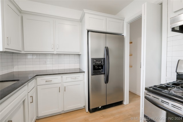 kitchen with white cabinetry, stainless steel appliances, decorative backsplash, and light wood-type flooring