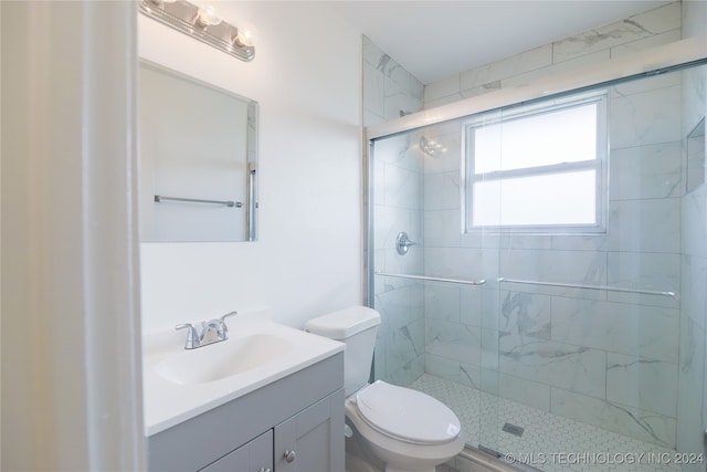 bathroom with toilet, an enclosed shower, and vanity