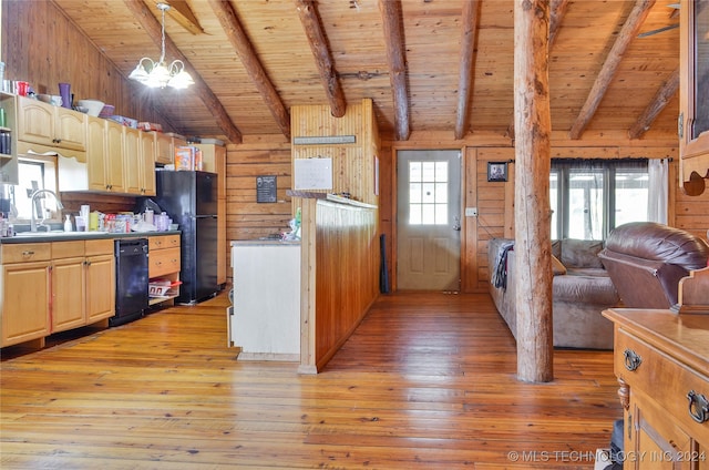 kitchen featuring a healthy amount of sunlight, sink, wooden walls, and light hardwood / wood-style flooring