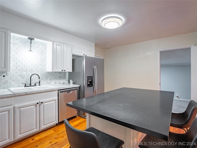 kitchen with appliances with stainless steel finishes, decorative backsplash, hanging light fixtures, and a breakfast bar area