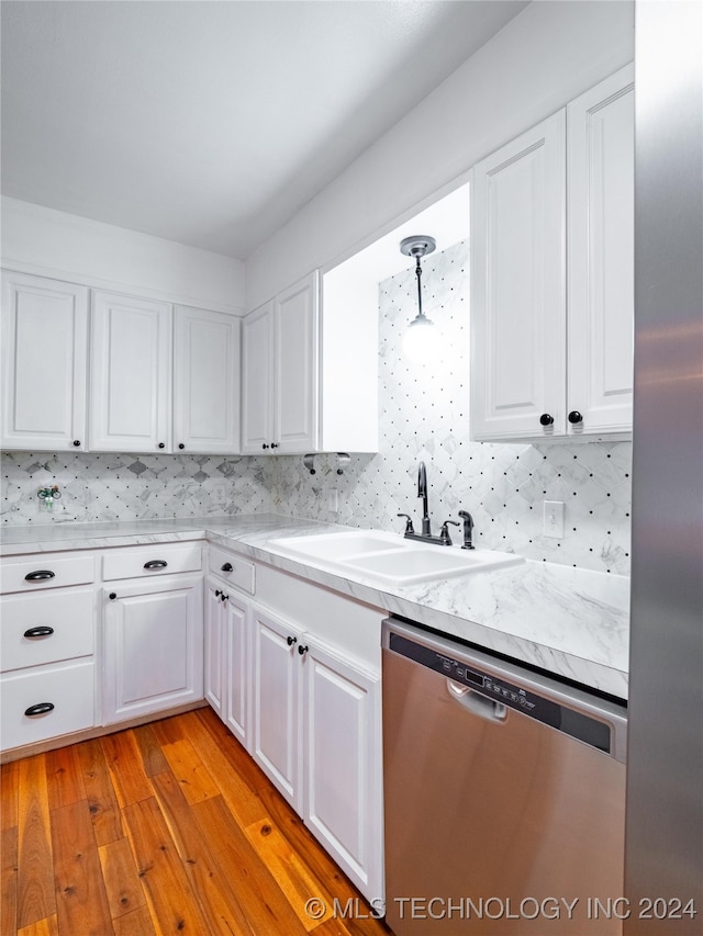 kitchen with sink, light wood-type flooring, hanging light fixtures, white cabinetry, and stainless steel dishwasher