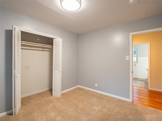 unfurnished bedroom with light hardwood / wood-style floors and a closet