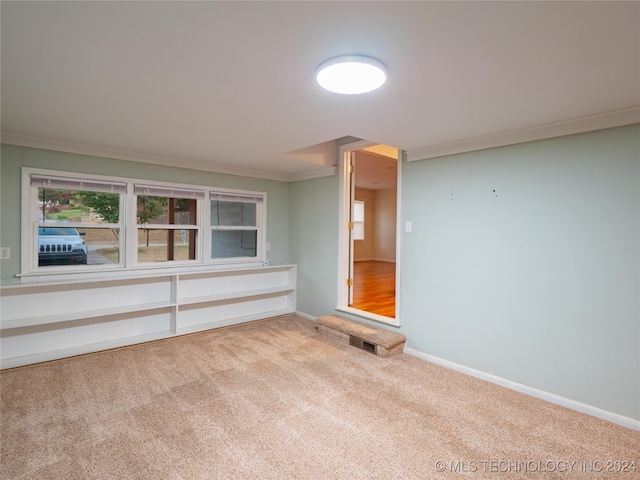 carpeted empty room featuring crown molding