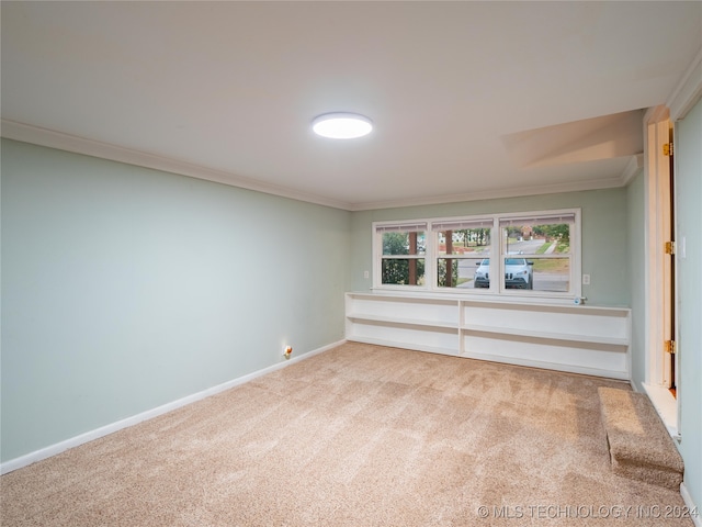 unfurnished room featuring ornamental molding and carpet