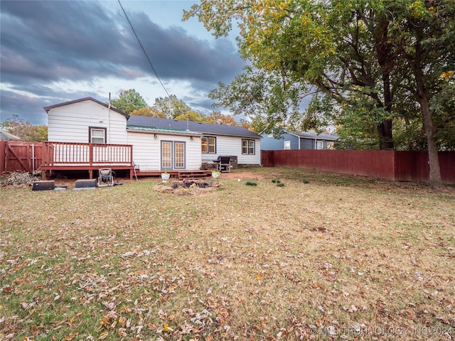 rear view of house featuring a yard and a deck