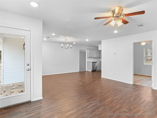 unfurnished living room with ceiling fan with notable chandelier and dark hardwood / wood-style flooring