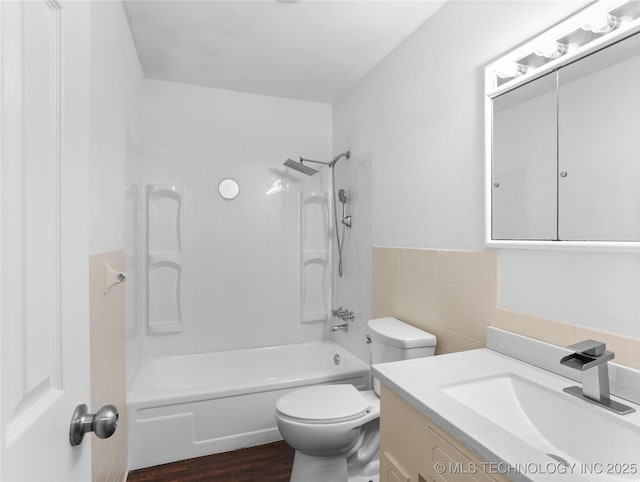 full bathroom with toilet, vanity, tile walls, and shower / bathing tub combination